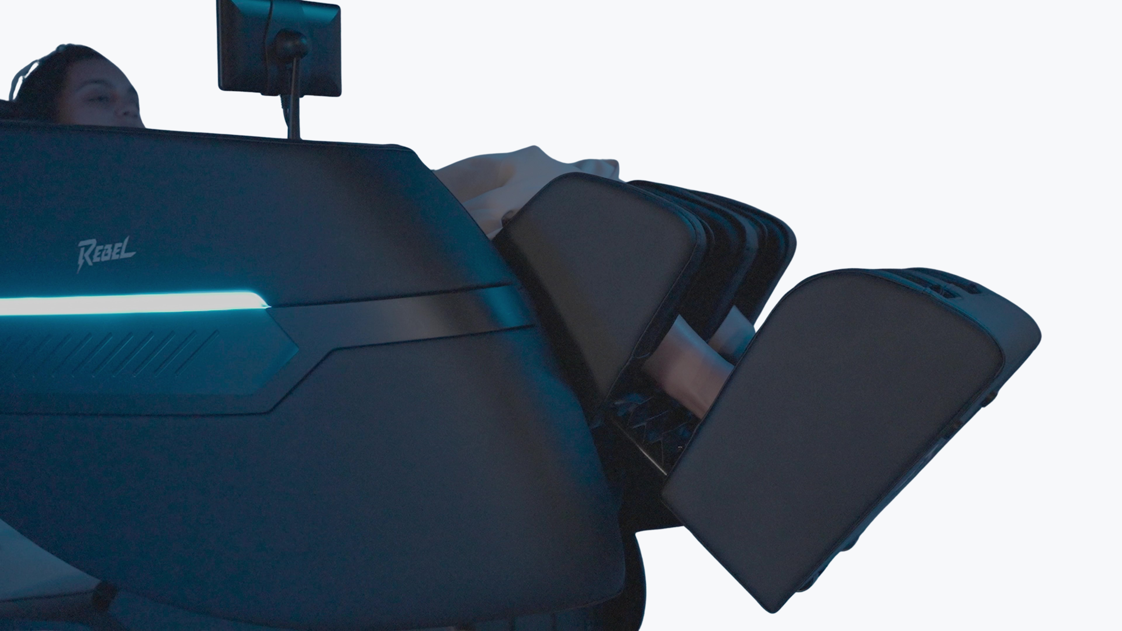 Close-up side view of person reclined in Floridian Brand Rebel 4D Massage Chair with elevated leg rest and blue LED strip