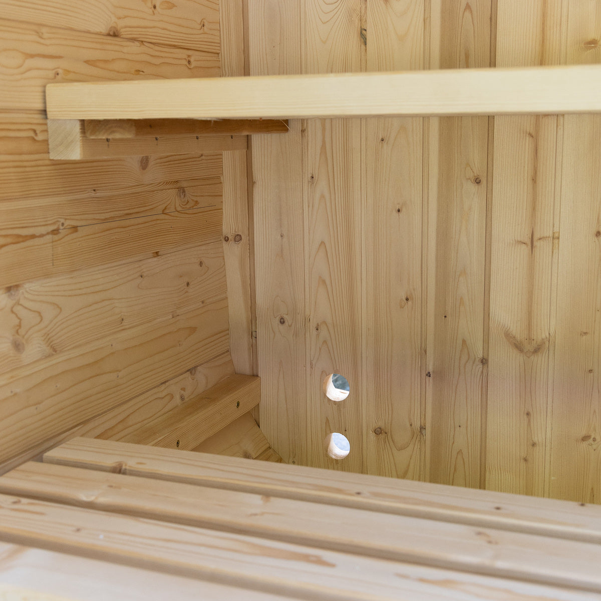 Auris One Luxury Outdoor Cedar Sauna interior corner view showing cedar wall planks bench rail and ventilation holes