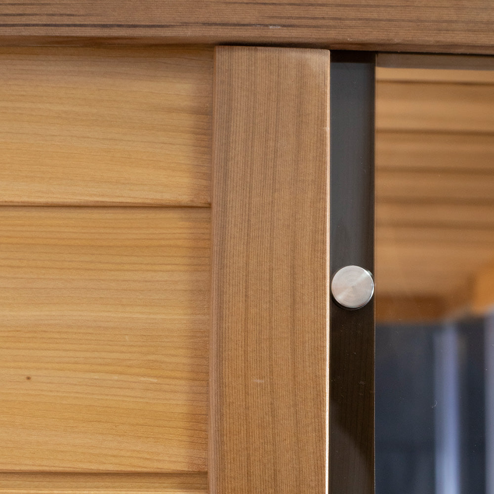 WizziSaunas SR01 Red Cedar Infrared Sauna close-up of cedar wood wall panel corner joint with stainless steel magnetic door latch knob and tempered glass door edge