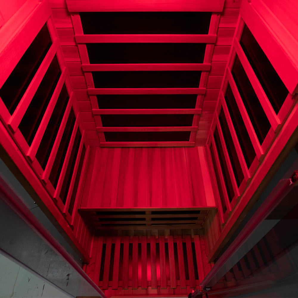 WizziSaunas SR01 Red Cedar Infrared Sauna top-down interior perspective view with vivid red chromotherapy lighting illuminating all carbon heater wall panels and cedar floor