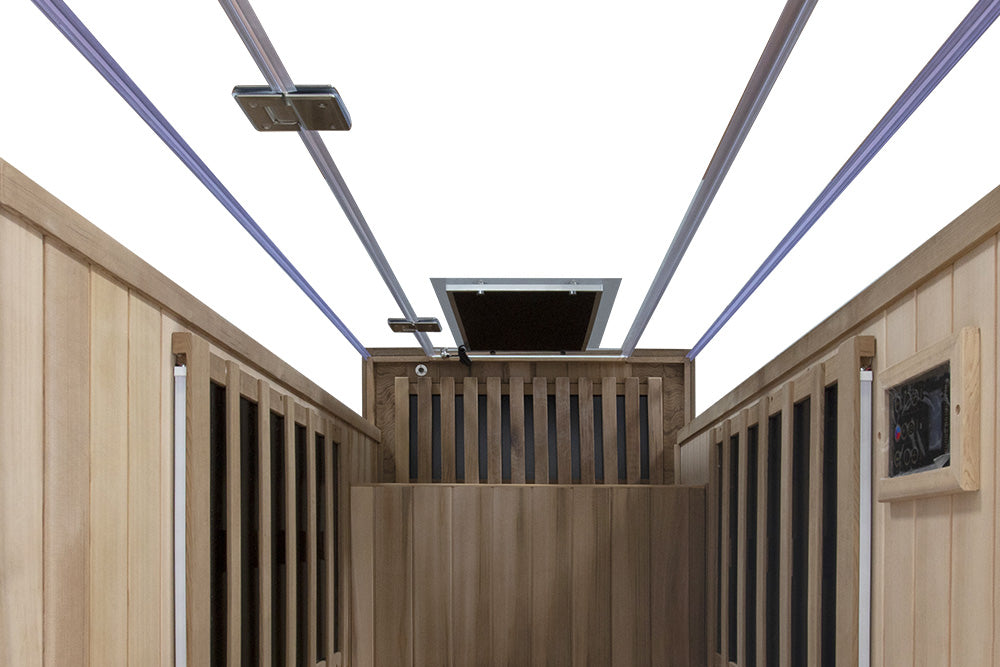 WizziSaunas SR01 Red Cedar Infrared Sauna interior upward view showing cedar walls carbon heater strips full spectrum ceiling heater open roof vent purple LED accent lighting and digital control panel on white background