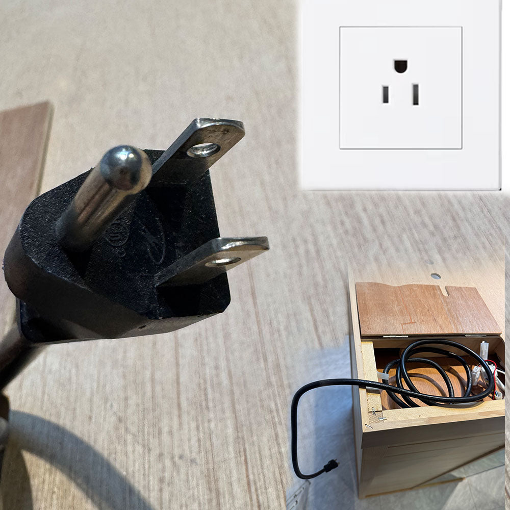 standard US household electrical cord with a wooden box and outlet in the background.