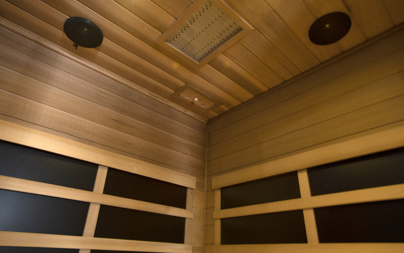WizziSaunas SR07 Red Cedar Infrared Sauna interior corner view showing ceiling with LED panel, speakers, and full spectrum infrared heating panels by WizziSauna